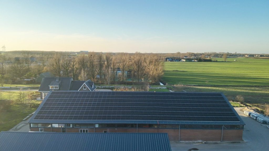 Zonnepanelen op bedrijfsgebouw in landelijke omgeving, duurzame energieoplossingen.