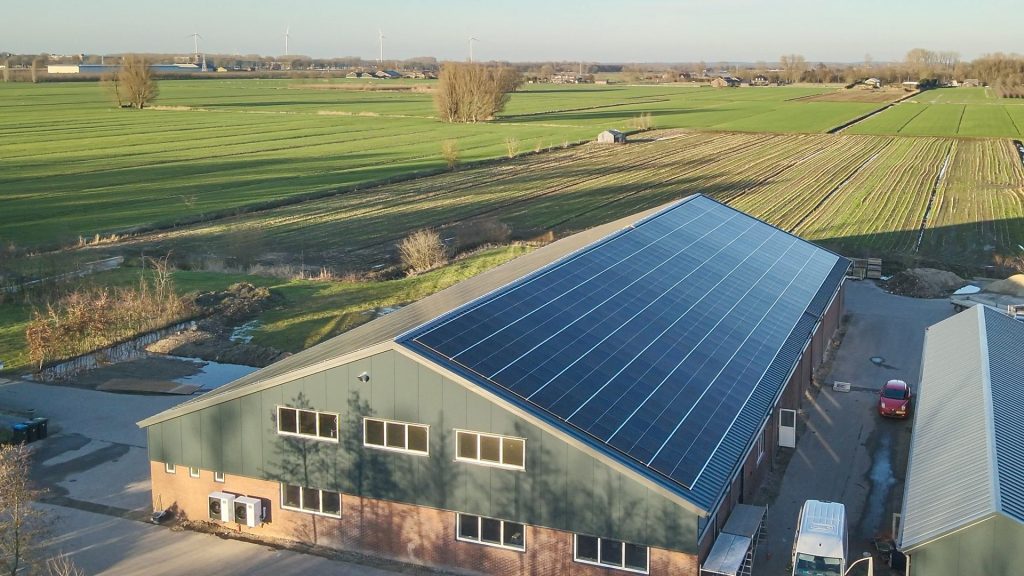 Zonnepanelen op bedrijfsgebouw in landelijke omgeving.